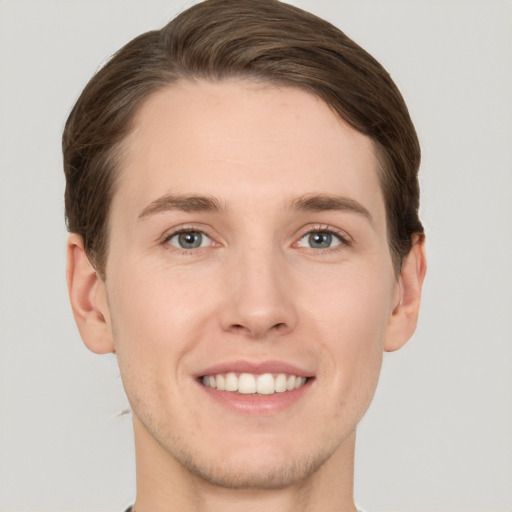 Joyful white young-adult male with short  brown hair and grey eyes