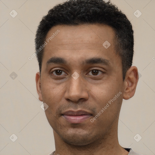 Joyful latino young-adult male with short  black hair and brown eyes