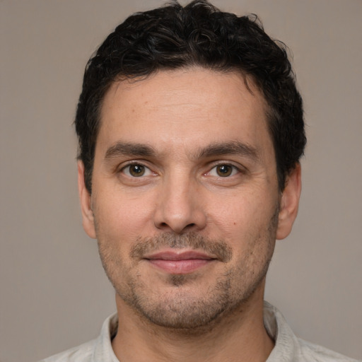 Joyful white young-adult male with short  black hair and brown eyes