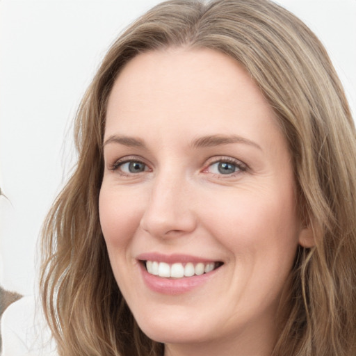 Joyful white young-adult female with long  brown hair and blue eyes