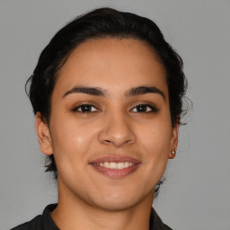 Joyful latino young-adult female with medium  brown hair and brown eyes