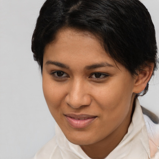Joyful latino young-adult female with short  brown hair and brown eyes