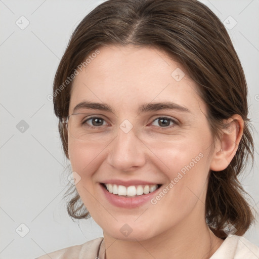 Joyful white young-adult female with medium  brown hair and grey eyes