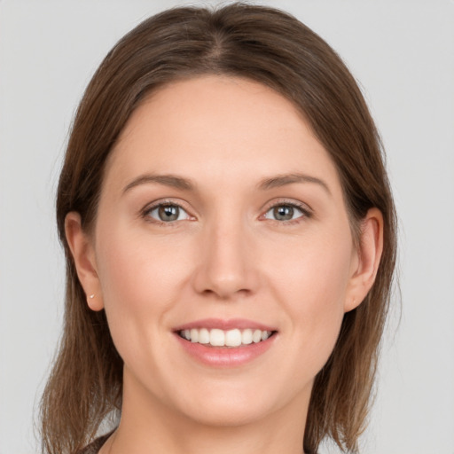 Joyful white young-adult female with medium  brown hair and grey eyes