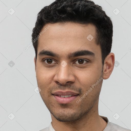 Joyful white young-adult male with short  black hair and brown eyes