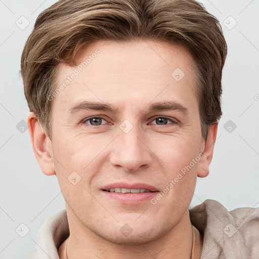 Joyful white young-adult male with short  brown hair and grey eyes