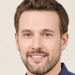 Joyful white young-adult male with short  brown hair and grey eyes