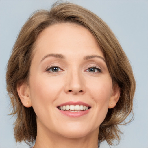 Joyful white adult female with medium  brown hair and grey eyes