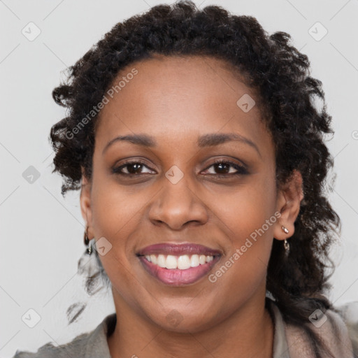 Joyful black young-adult female with long  brown hair and brown eyes