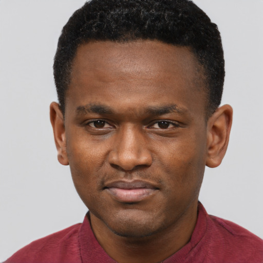 Joyful black young-adult male with short  brown hair and brown eyes