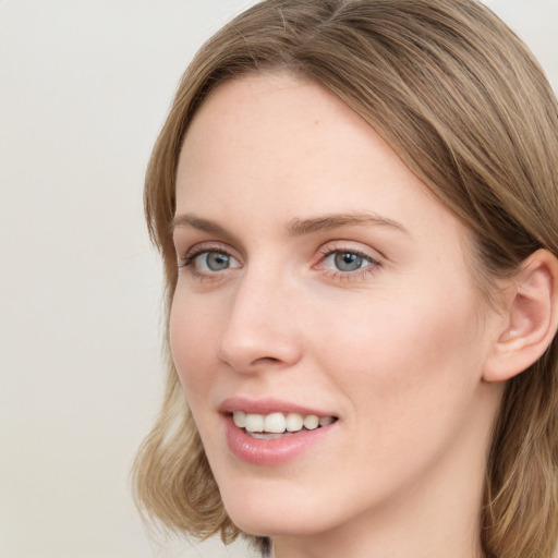 Joyful white young-adult female with long  brown hair and blue eyes