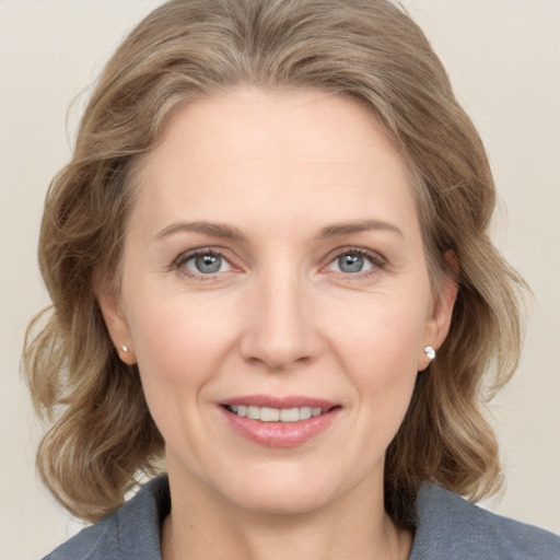 Joyful white adult female with medium  brown hair and grey eyes