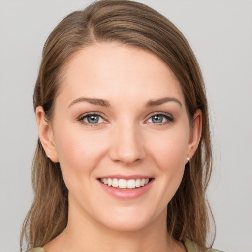 Joyful white young-adult female with medium  brown hair and grey eyes