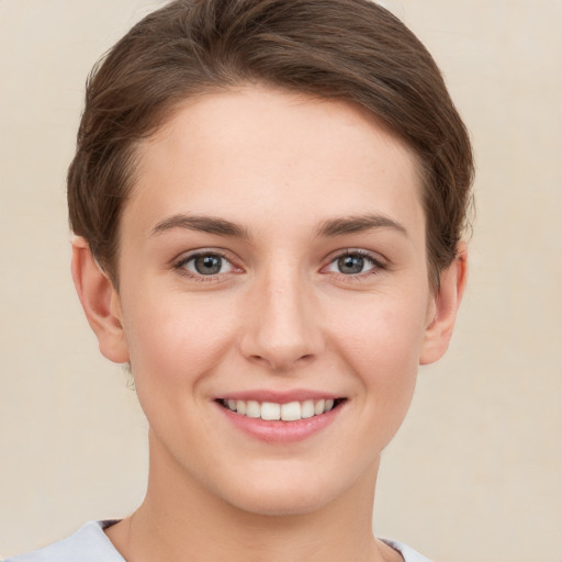 Joyful white young-adult female with short  brown hair and grey eyes