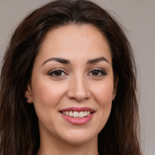 Joyful white young-adult female with long  brown hair and brown eyes