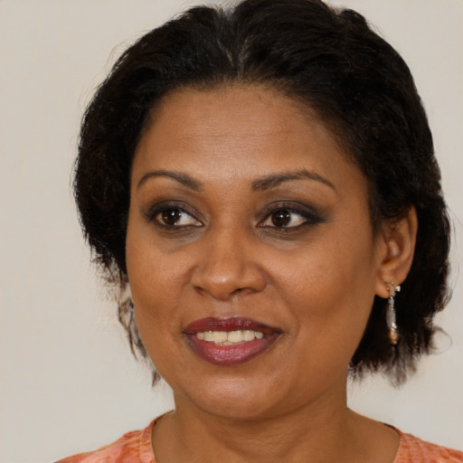 Joyful black adult female with medium  brown hair and brown eyes