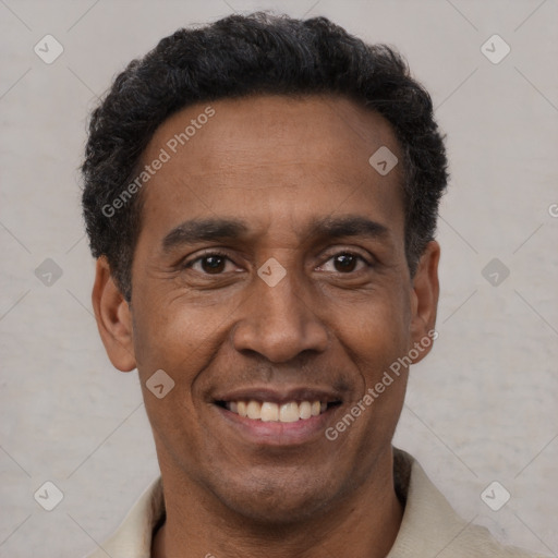 Joyful black adult male with short  black hair and brown eyes