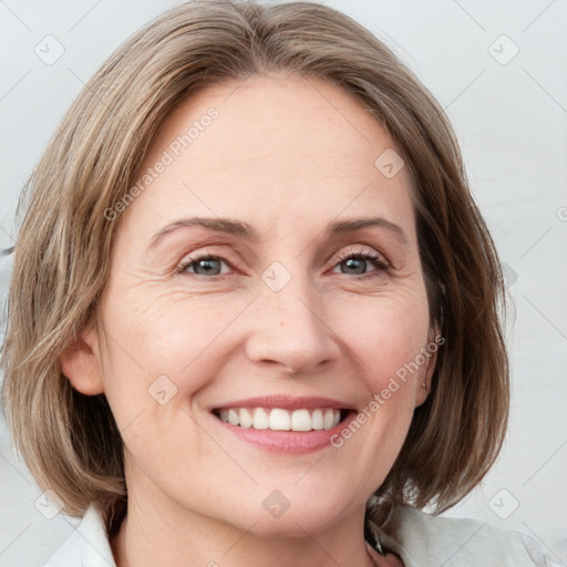 Joyful white adult female with medium  brown hair and blue eyes