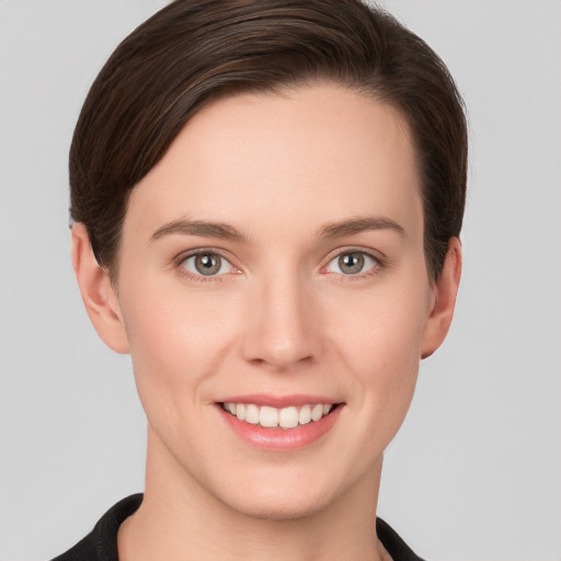 Joyful white young-adult female with short  brown hair and grey eyes