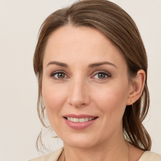 Joyful white young-adult female with medium  brown hair and grey eyes