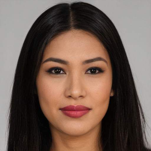 Joyful latino young-adult female with long  black hair and brown eyes