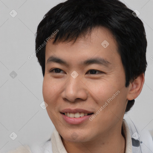 Joyful asian young-adult male with short  brown hair and brown eyes