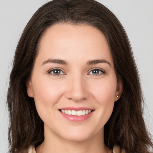 Joyful white young-adult female with long  brown hair and brown eyes