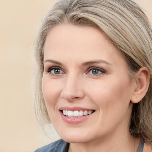 Joyful white young-adult female with medium  brown hair and blue eyes