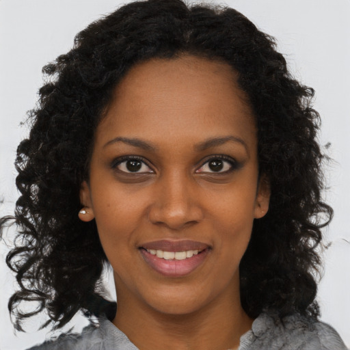Joyful black young-adult female with medium  brown hair and brown eyes