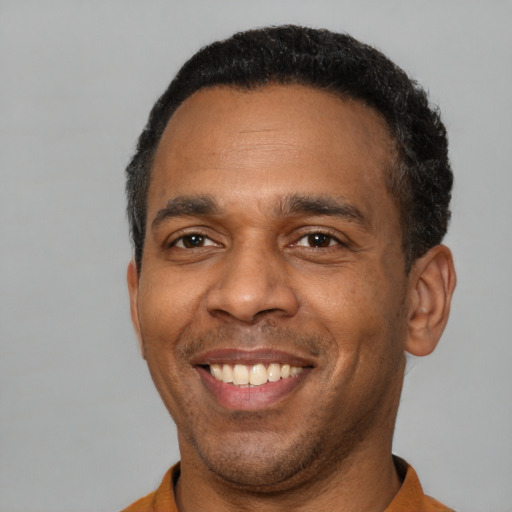 Joyful latino adult male with short  black hair and brown eyes