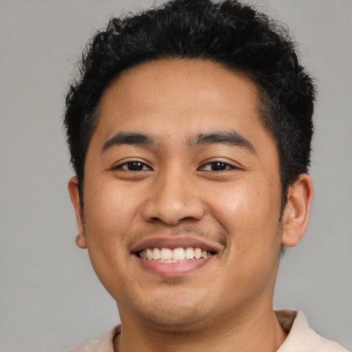 Joyful latino young-adult male with short  black hair and brown eyes