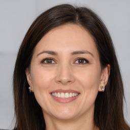 Joyful white adult female with long  brown hair and brown eyes