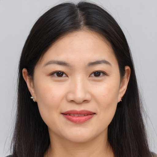 Joyful asian young-adult female with long  brown hair and brown eyes