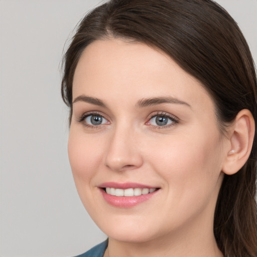 Joyful white young-adult female with long  brown hair and grey eyes