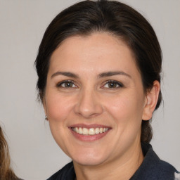 Joyful white adult female with medium  brown hair and brown eyes