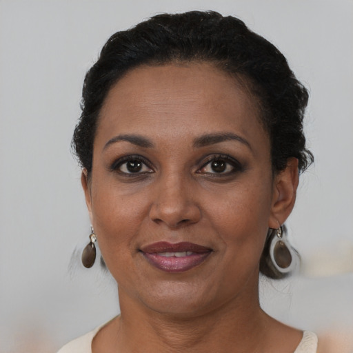 Joyful black adult female with short  brown hair and brown eyes