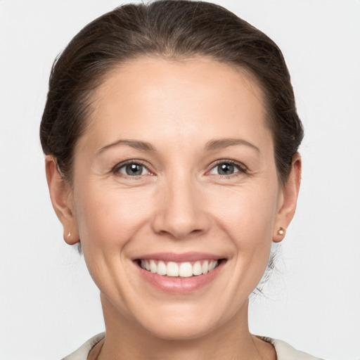 Joyful white young-adult female with medium  brown hair and grey eyes