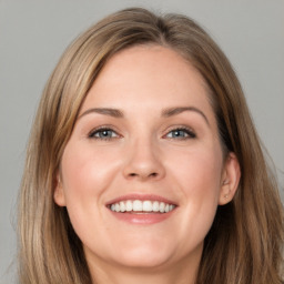 Joyful white adult female with long  brown hair and blue eyes