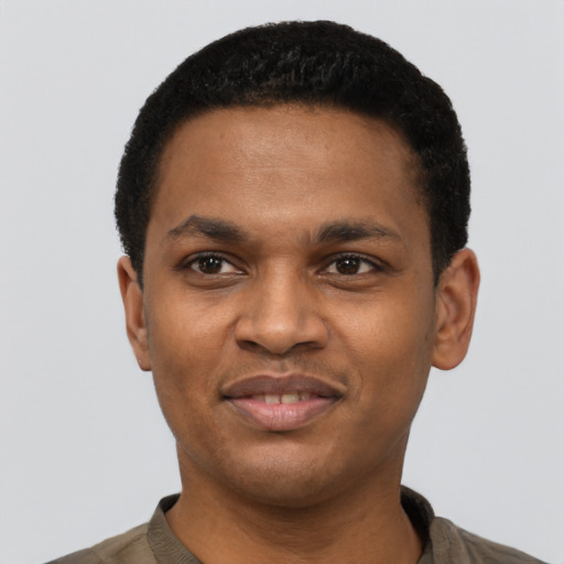 Joyful black young-adult male with short  black hair and brown eyes