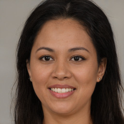 Joyful latino young-adult female with long  brown hair and brown eyes