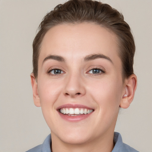 Joyful white young-adult female with short  brown hair and grey eyes