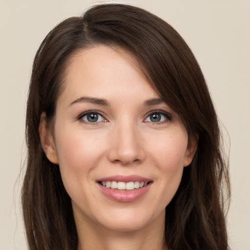 Joyful white young-adult female with long  brown hair and brown eyes