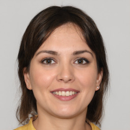 Joyful white young-adult female with medium  brown hair and brown eyes