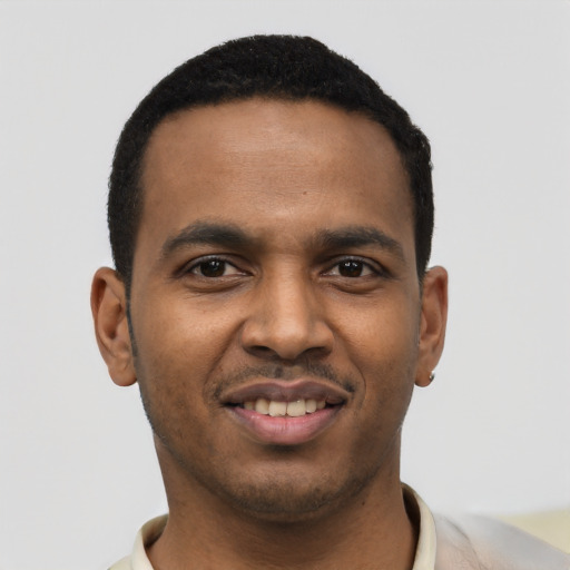 Joyful black young-adult male with short  black hair and brown eyes