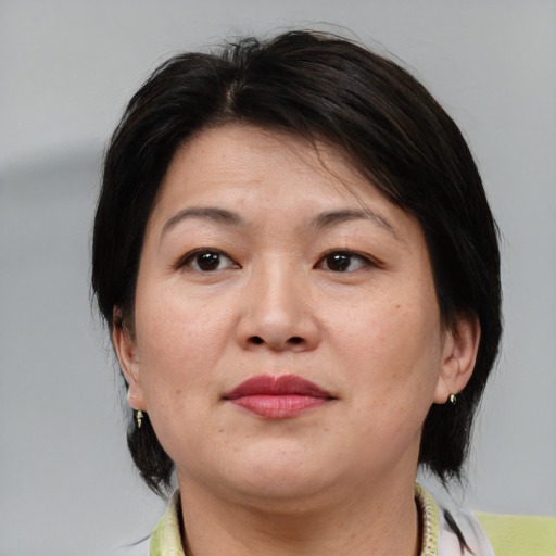 Joyful asian adult female with medium  brown hair and brown eyes