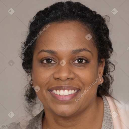 Joyful black young-adult female with long  brown hair and brown eyes