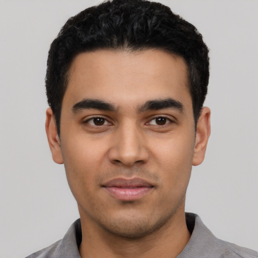 Joyful latino young-adult male with short  black hair and brown eyes