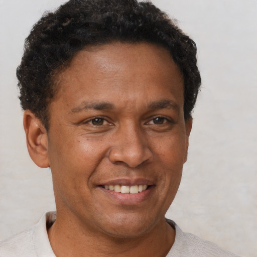 Joyful black adult male with short  brown hair and brown eyes