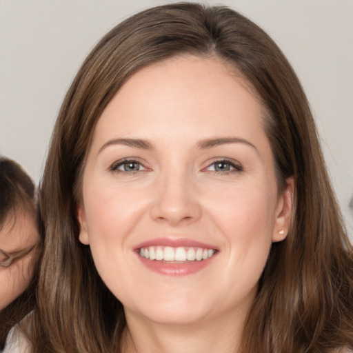 Joyful white young-adult female with long  brown hair and brown eyes