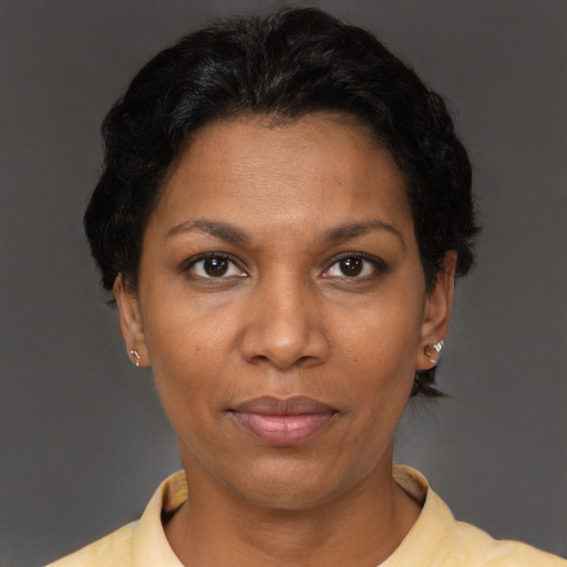 Joyful black adult female with short  brown hair and brown eyes